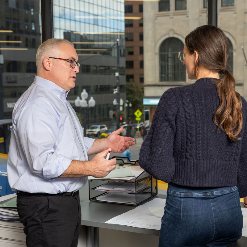 Two colleagues discussing an architectural plan.